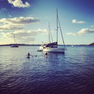 Boats sailing in sea against sky