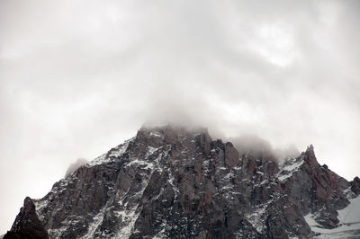 Low angle view of snowcapped mountain against sky