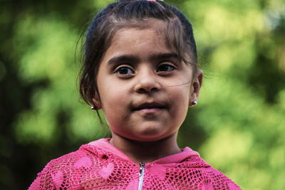 Close-up of cute girl looking away in park