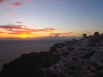 Panoramic view of sea and buildings against sky during sunset