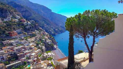 High angle view of townscape by sea against sky