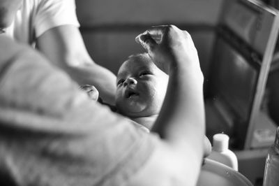 Close-up of hands holding newborn baby in hospital