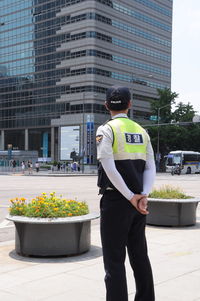 Rear view of police man standing on street