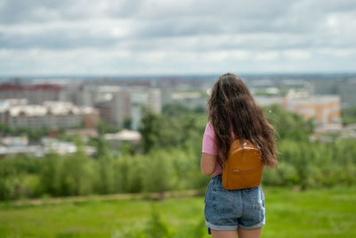 Rear view of woman standing against sky