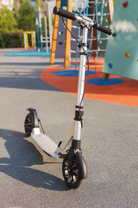 Low section of man riding push scooter on road