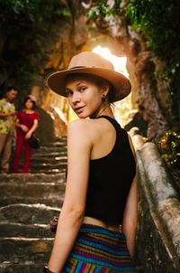 Full length of woman wearing hat standing against trees