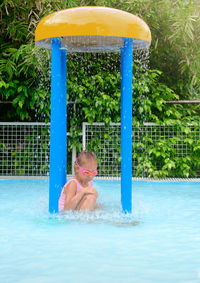 Rear view of woman swimming in pool