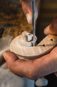Violin maker luthier hand working a new violin scroll