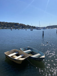 Sailboats moored in sea against clear sky