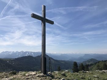 Cross on mountains against sky