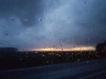 Raindrops on window during sunset