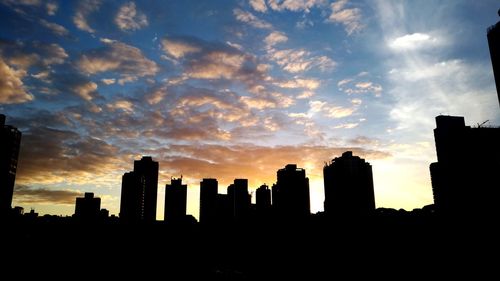 Silhouette buildings against sky during sunset