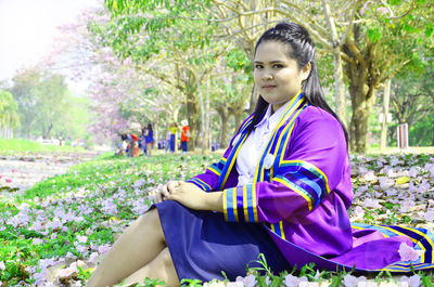 Portrait of young woman sitting on field