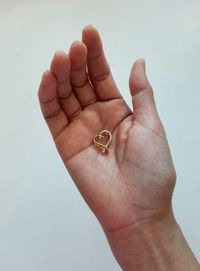 Gold heart pendant inlaid with diamonds,  hand holding  