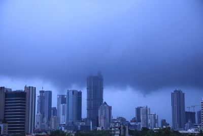 Modern buildings in city against blue sky