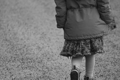 Midsection of girl walking on road