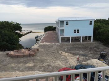 Houses by sea against sky
