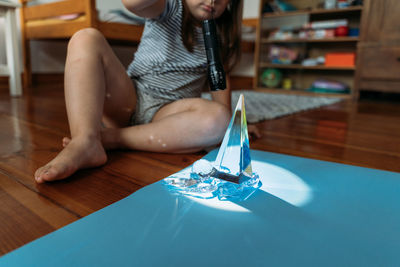 High angle view of young woman drinking water on table