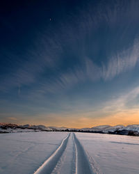 Snow covered landscape against sky