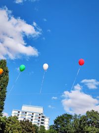 Low angle view of balloons against blue sky