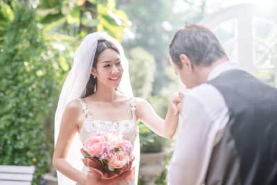 Loving wedding couple standing at backyard