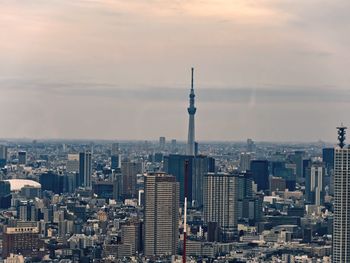 Modern buildings in city against cloudy sky