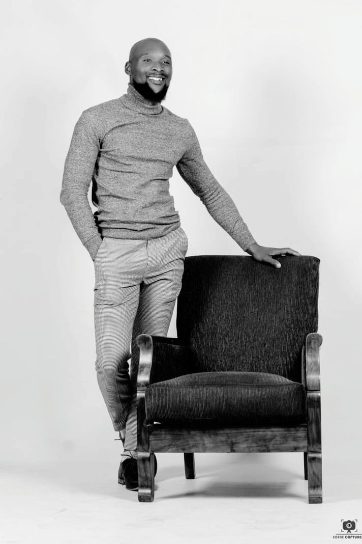 sitting, adult, full length, one person, portrait, black and white, indoors, black, furniture, photo shoot, monochrome photography, looking at camera, studio shot, casual clothing, white, chair, monochrome, men, clothing, standing, smiling, person, footwear, emotion, fashion, young adult, happiness, white background, lifestyles, front view, women