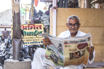 Portrait of man sitting in city