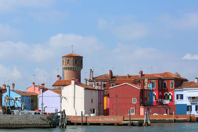Buildings in city against cloudy sky