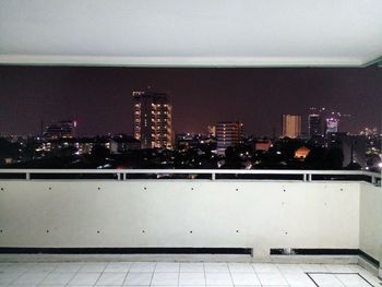 Illuminated cityscape against sky at night