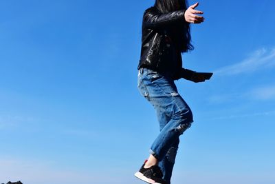 Side view of woman against blue sky