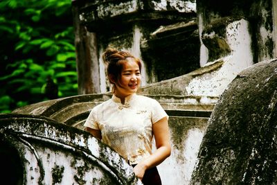 Smiling beautiful woman standing at abandoned building