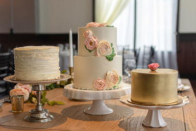 Wedding cake trio with gold, ruffles, and edible roses