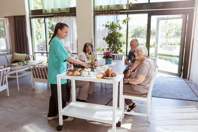 Happy friends sitting on table