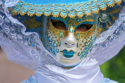 Close-up portrait of young woman wearing mask and hat