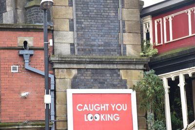 Close-up of road sign against built structure
