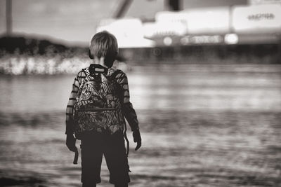 Rear view of a boy looking at water