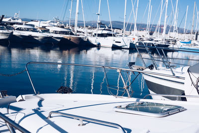 Sailboats moored at harbor