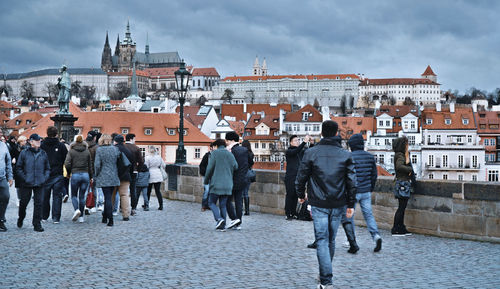 Rear view of people walking on street in city