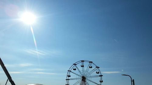 Low angle view of ferris wheel against blue sky