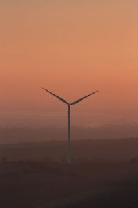 Wind turbine silhouette at the sunset time