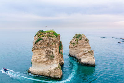 Rock formations in sea against sky