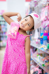 Close-up of cute girl holding doll while standing in store