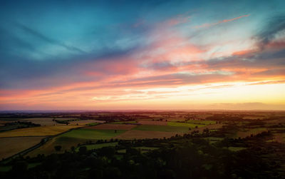 Scenic view of agricultural field against sky during sunset