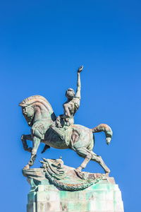 Low angle view of statue against clear blue sky