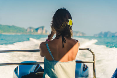 Rear view of woman looking at sea against sky