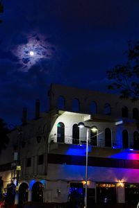 Low angle view of illuminated buildings against sky at night