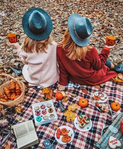 Rear view of female friends enjoying picnic during halloween