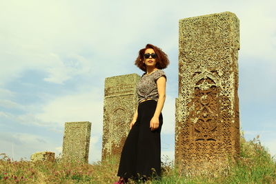 Woman standing by plants against sky