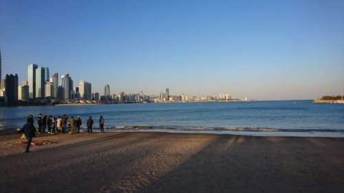 Scenic view of sea by buildings against clear sky